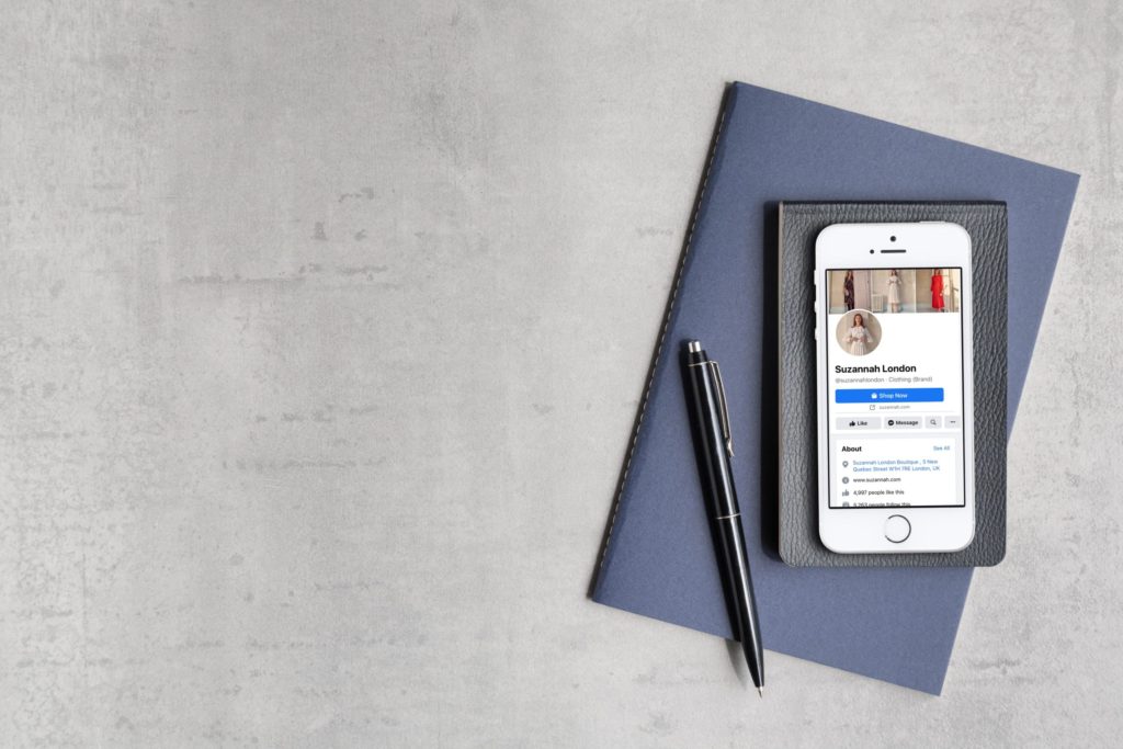 Iphone 5 displaying the Facebook page of luxury brand, Suzannah showing the importance of the Facebook pixel
